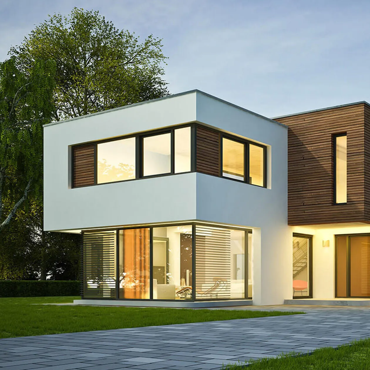 Ein Haus am Abend. Lichter im Inneren des Hauses beleuchten die Räume.